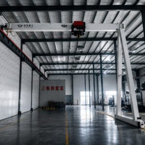 Semi gantry crane operating on elevated runway beam and ground rail